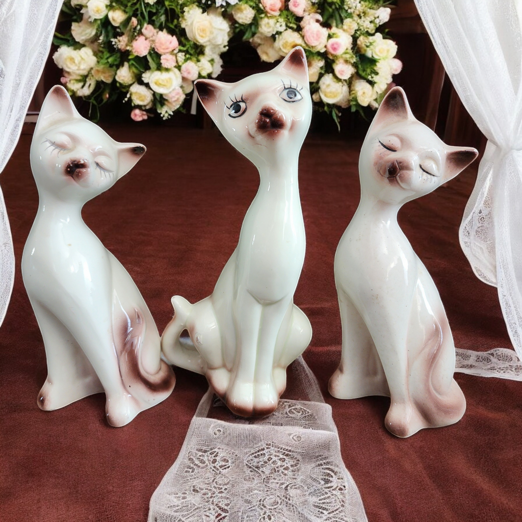 Three Stylized Porcelain Cat Figurines Each with Distinct Pose