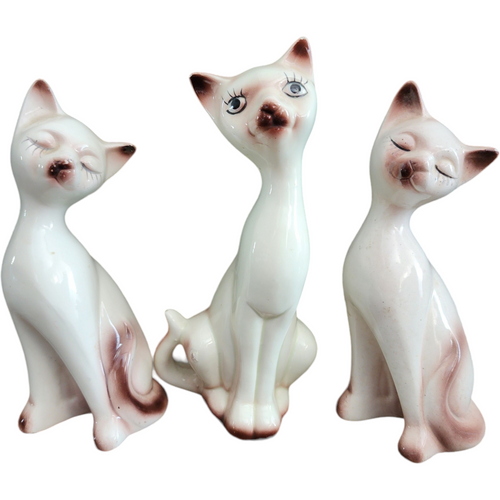 Three Stylized Porcelain Cat Figurines Each with Distinct Pose